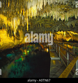 Le grotte di cristallo con bellissime stalattiti pendenti illuminato dai fari di lavoro ad alta intensità luminosa e riflessa nel lago sotterraneo Bermuda Foto Stock