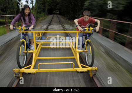 Due bambini in sella a una moto speciale su un binario ferroviario Foto Stock