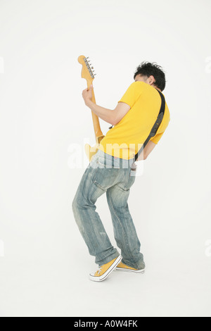 Vista posteriore di un giovane uomo di suonare una chitarra elettrica Foto Stock