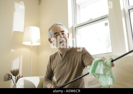 Close up di un anziano uomo seduto su un divano e la pulizia di una golf club Foto Stock