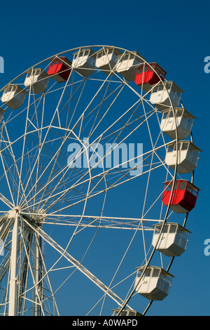 Rosso e bianco carrelli vuoti su una ruota panoramica Ferris in un parco di divertimenti. Foto Stock