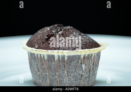 Close up di un muffin al cioccolato su una piastra di sfondo nero Foto Stock