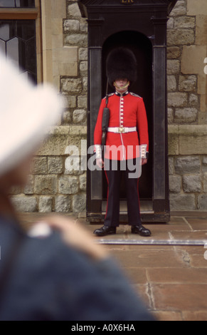 Inghilterra London Tourist con la fotocamera sta davanti a una guardia reale presso la Torre di Londra Foto Stock