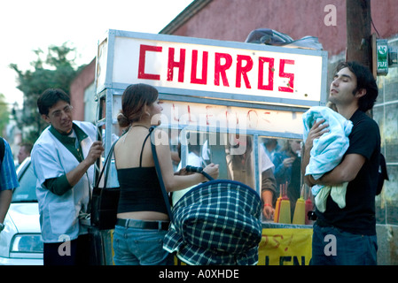 Giovane comfort il loro bambino da un alimento bancarella vendendo churros in Coyoacan Città Del Messico Foto Stock