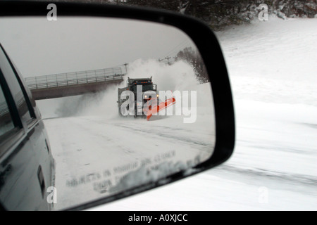 Carrello spazza la neve sulla strada statale del New Hampshire Foto Stock