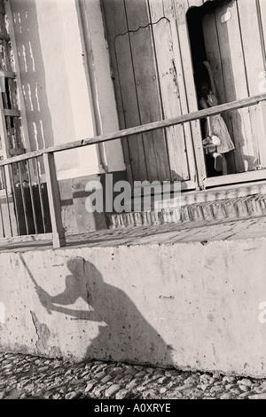 CUBA TRINIDAD i giovani a giocare a baseball le loro ombre su una parete come un bambino entra home Foto Stock