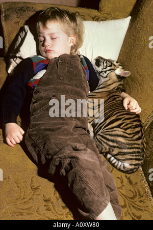 7 anni Megan Whittaker con cucciolo di tigre indiano allevato a mano (Panthera tigris tigris. Port Lympne Wild Animal Park, Kent, Regno Unito Foto Stock