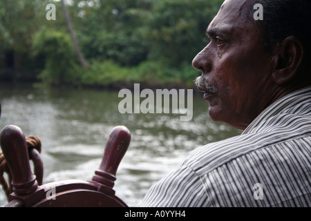 Ritratto di un uomo che guida una barca casa su le lagune del Kerala, in India Foto Stock