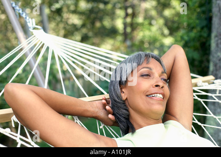 Di mezza età donna africana per rilassarsi in un'amaca Foto Stock