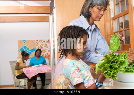 Giovane ragazza africana la cottura con sua nonna Foto Stock