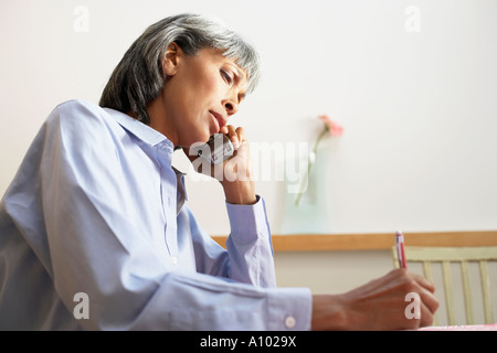 Di mezza età donna africana parla al telefono Foto Stock