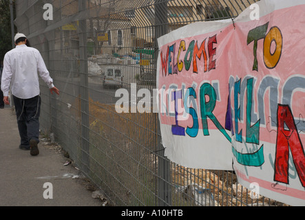 Israele Gerusalemme ultra ortodosso vicinato di Mea Shearim ebreo ortodosso a piedi da alta recinzione metallica con poster colorati Welco Foto Stock