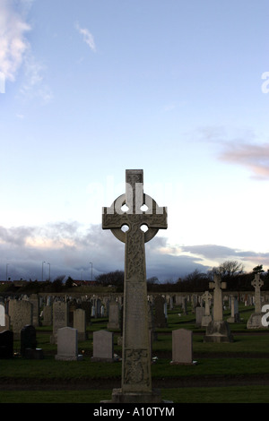 Una croce celtica pietra tombale contro un cielo blu nel cimitero di Troon Scozia Scotland Foto Stock