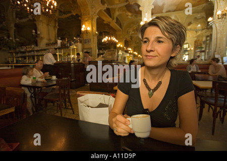 Una giovane donna single in attesa 'Grand Cafe' di Moulins. Jeune femme patientant dans le 'Grand Café de Moulins (Francia). Foto Stock