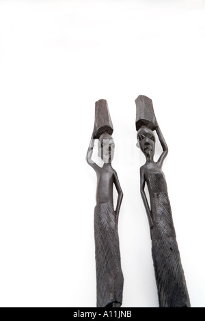 Statue di ebano dall Africa: l uomo e la moglie di trasportare pesi sulla loro testa isolata su sfondo bianco Foto Stock