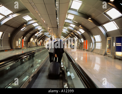 Airport ravelers on a conveyor s belt Frankfurt am Main Intl Airport Germany Foto Stock