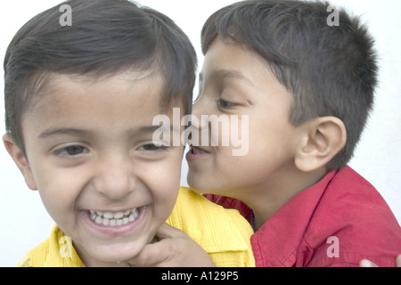 Ragazzi che sussurrano sorridendo ridendo giocando Foto Stock