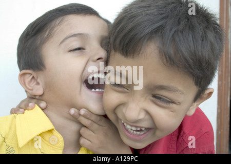 Ragazzi che sussurrano sorridendo ridendo giocando Foto Stock