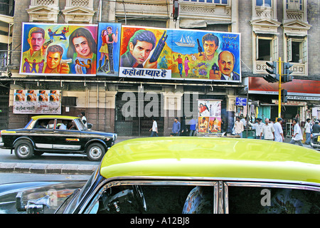 Scena di strada indiana con taxi sul tetto giallo nero con sala film Bollywood Hindi Capitol Cinema al VT CST Bombay Mumbai Maharashtra India Asia Foto Stock