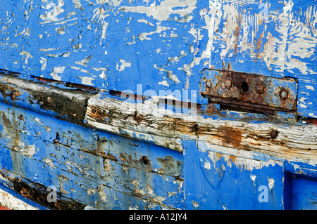 Abstract sullo sfondo di un vecchio peschereccio a Folkestone nel Kent REGNO UNITO a scaglie blu vernice sbiancato scafo in legno Foto Stock