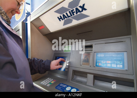 Halifax outdoor bancomat donna keying in per accedere a UK Regno Unito Inghilterra Europa GB Gran Bretagna UE Unione Europea Foto Stock