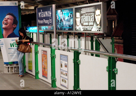 Ragazza in attesa presso una stazione BTS Skytrain Bangkok in Thailandia Foto Stock