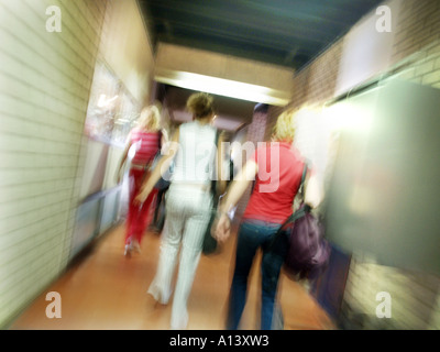 Gli adolescenti correre attraverso il corridoio della scuola visto da dietro Foto Stock