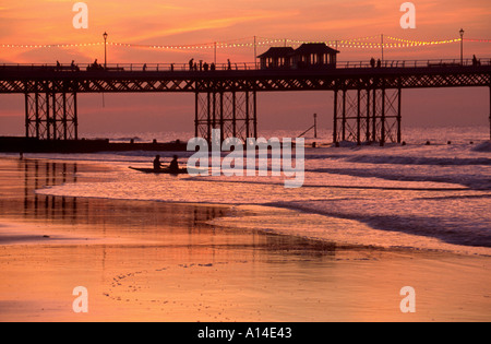 Due persone in canoa entrando in mare a cromer con pier in background norfolk Foto Stock