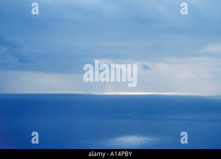 Raggi di sole e nuvole sopra il Mar Ligure al largo della costa di Italia Foto Stock