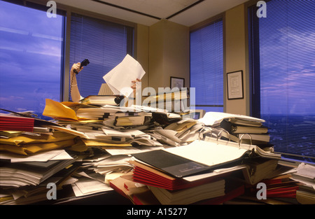 Una imprenditrice è nascosto dietro un enorme pila di libri in file angolo ufficio della grande impresa corporate Foto Stock