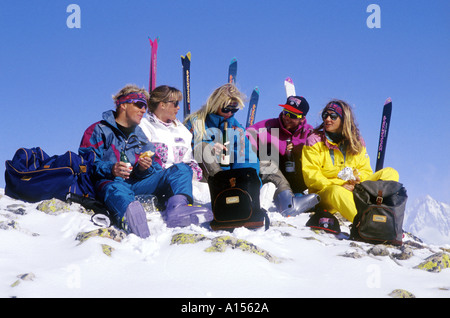 Cinque sciatori avente un picnic nella neve Foto Stock