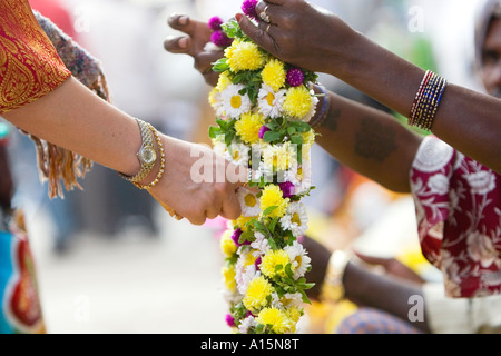 Western devoto acquisto ghirlanda di fiori da indiano street commerciante a Puttaparthi , India meridionale. messa a fuoco selettiva Foto Stock