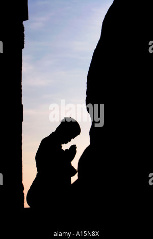 Profilo di Silhouette indiana di uomo che prega al tempio indù contro il cielo blu. Lepakshi, Andhra Pradesh, India Foto Stock