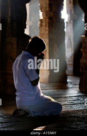 Giovani indiani uomo prega nel tempio Lepakshi , India meridionale Foto Stock