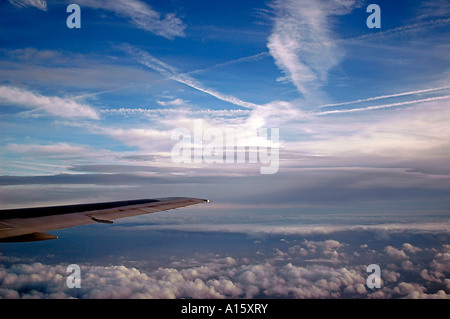 Antenna orizzontale vista da un aereo finestra del cielo blu con i modelli di vapor trails criss crossing in alto al di sopra Foto Stock