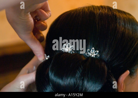 Chiudere orizzontale di un parrucchiere mettendo il tocco finale per una sposa i capelli. Foto Stock