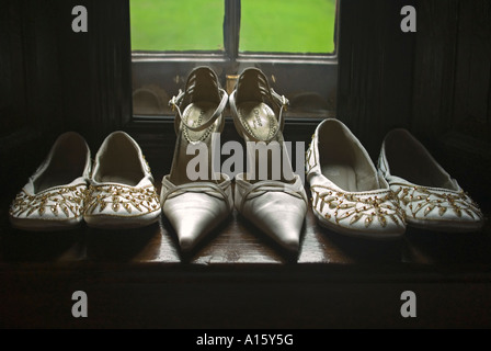 Chiudere orizzontale del nuovo di zecca scarpe sposa e le sue damigelle hanno bordato pantofole pronto per un matrimonio. Foto Stock
