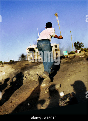 Un palestinese getta una roccia a soldati israeliani in Cisgiordania città di Ramallah giovedì 12 ottobre 2000. Foto Stock