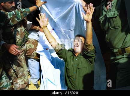 Un palestinese soldato alza le mani ed esprime la sua disperazione dopo aver sepolto Abdelgadr Musbah Abu Atig 27 che è stato ucciso da Foto Stock