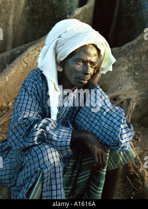 Un Fulani da un villaggio della Casamance territorio tra i paesi dell' Africa occidentale della Guinea Bissau e Senegal si siede su un Foto Stock