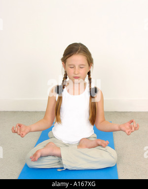 Bambina di otto anni la pratica dello yoga gli occhi chiusi Foto Stock