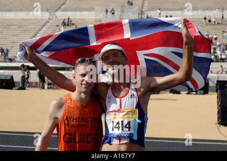 Paolo Pearce della Gran Bretagna mantiene la Union Jack con la sua guida dopo il T13 categoria maratona Foto Stock