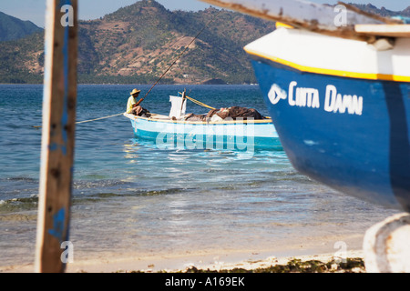 Uomo seduto sulla barca da pesca, Gili Air Foto Stock