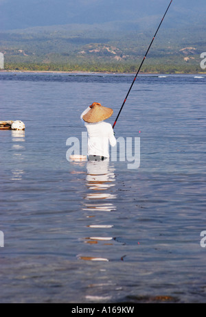 Uomo in piedi nella pesca in mare Foto Stock