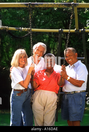 Pensionati e caucasici americano africano aventi coppie di divertimento nel parco Foto Stock