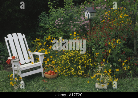 Pranzo privato in giardino: fresco raccolto il pomodoro si siede su una piastra su una sedia di legno con un cesto di pomodori e fantasia birdbox verniciato, Midwest USA Foto Stock