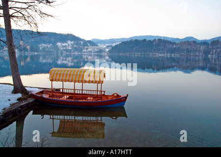 Una barca si trova ancora sul lago di Bled, Slovenia. Foto Stock