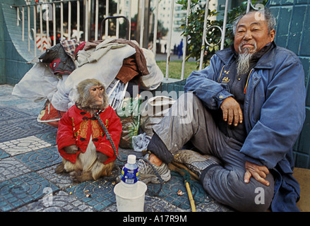 Un uomo cinese e la sua scimmia. Foto scattata a Xiamen, provincia di Fujian, Cina. Foto Stock