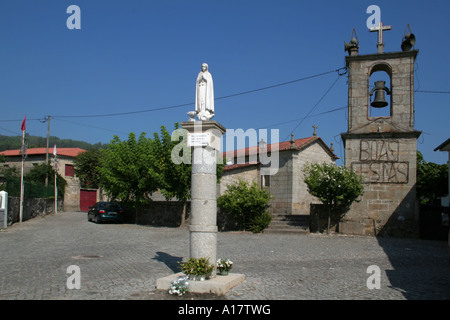 Lanhoso chiesa con una statua della Madonna di Fatima nel centro della piazza. Il Portogallo. Foto Stock