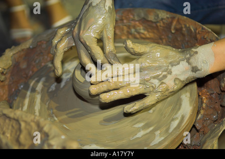 Close up dei vasai mani gettando una pentola sulla ruota girevole Foto Stock